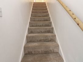 A stairwell with carpeted stairs and a wooden handrail at Lonsdale Street
