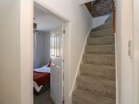A hallway with staircase and a bedroom door at Lonsdale Street