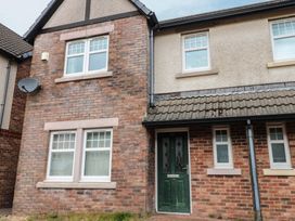 A house exterior with a green door and brick walls at Lingla House in Frizington