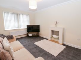 A living room with a television and sofa at Lingla House in Frizington