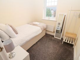 A bedroom with a single bed and a mirror at Lingla House in Frizington