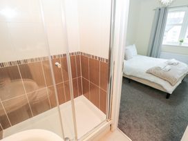 A bathroom with a shower and view of a bedroom at Lingla House in Frizington