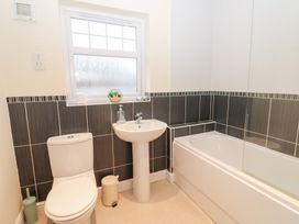 A bathroom with a toilet, sink, and bath at Lingla House in Frizington