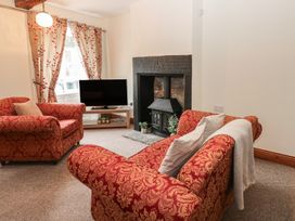 A living room with a TV and sofa at Kirkgate Cottage in Cockermouth