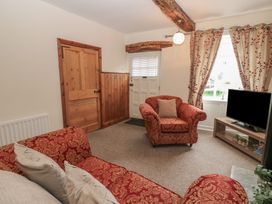 A living room with a door and an armchair at Kirkgate Cottage in Cockermouth