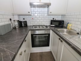 A kitchen with appliances and countertop at Kirkgate Cottage in Cockermouth