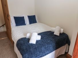 A bed with pillows and towels at Kirkgate Cottage in Cockermouth