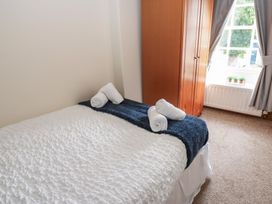 A bedroom with a bed and wardrobe at Kirkgate Cottage Cockermouth