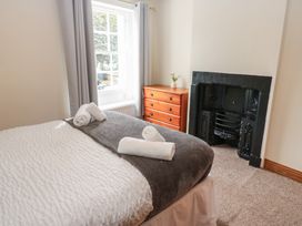 A bedroom with a bed and dresser at Kirkgate Cottage in Cockermouth