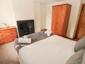 A bedroom with a bed and wardrobe at Kirkgate Cottage in Cockermouth