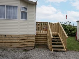 An outdoor area with a wooden deck and steps at Puffin in St Bees
