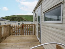 A deck area with a wooden gate and door at Puffin in St Bees