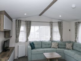 A living room with a sofa and television at Puffin in St Bees