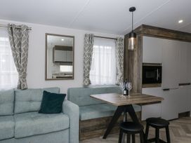 A living room with a sofa and dining area at Puffin in St Bees