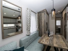 A dining room with a table and sofa at Puffin in St Bees