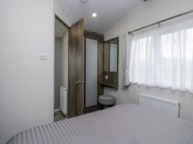 A bedroom with a bed and a mirror at Puffin in St Bees