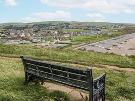 A coastal view with a bench overlooking the sea and houses at Puffin in St Bees