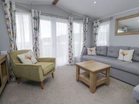 A living room with a sofa and armchair at Sandpiper in St Bees