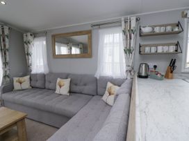 A living room with a sofa and coffee table at Sandpiper in St Bees