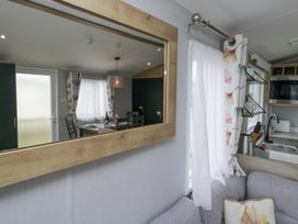 A living room with a dining area and kitchen at Sandpiper in St Bees