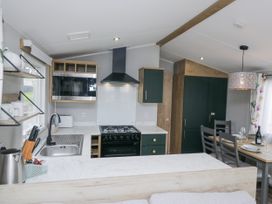 A kitchen with appliances and dining area at Sandpiper in St Bees