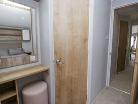 A bedroom with a vanity and mirror at Sandpiper in St Bees