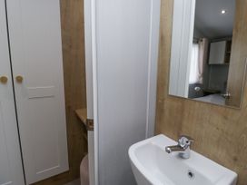 A bathroom with a sink and mirror at Sandpiper in St Bees