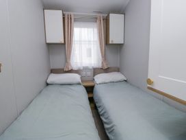 A bedroom with two beds and a window at Sandpiper in St Bees