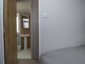 A bathroom with a washbasin and door at Sandpiper in St Bees
