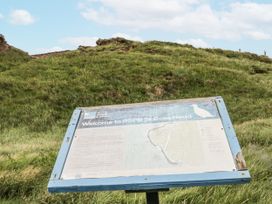 A sign at RSPB St Bees Head with grass and hills in the background