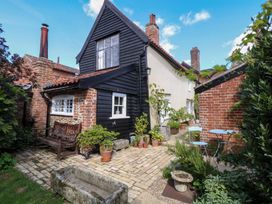 A garden with a house and outdoor seating at Bank House