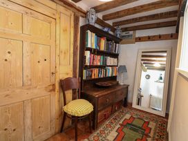A hallway with bookshelves and a chair at Bank House