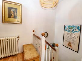 A staircase with a painting and poster at Bank House