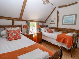 A bedroom with two beds and wooden features at Bank House
