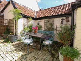 An outdoor patio with a table and chairs at Bank House in 
