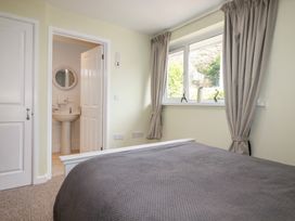 A bedroom with a bed and window at Mini Mena in St Austell