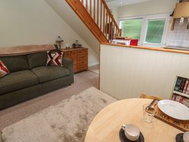 A living room with a sofa and a dining table at Mini Mena in St Austell