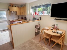 A kitchen with a dining table and TV at Mini Mena in St Austell