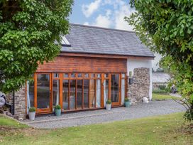 An exterior view of a building with large windows at Church Barn in Sutcombe near Bradworthy