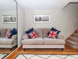 A living room with a sofa and stairs at Church Barn Sutcombe near Bradworthy