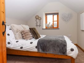 A bedroom with a bed and decorative wall elements at Church Barn Sutcombe near Bradworthy