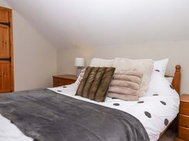 A bedroom with a bed and nightstand at Church Barn in Sutcombe near Bradworthy