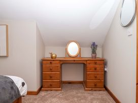 A bedroom with a wooden desk and mirror at Church Barn in Sutcombe near Bradworthy