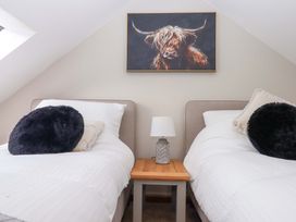 A bedroom with two beds and a painting at Church Barn Sutcombe near Bradworthy