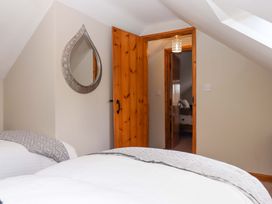 A bedroom with beds and a mirror at Church Barn Sutcombe near Bradworthy