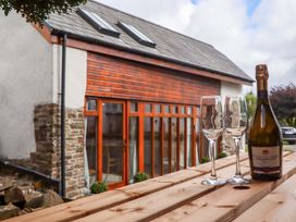 A bottle of prosecco with glasses on a wooden table at Church Barn Sutcombe near Bradworthy