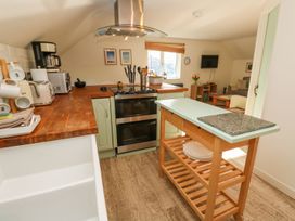 A kitchen with a stove, sink, and kitchen island at Five Elements Barn in Truro