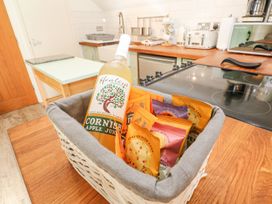 A bottle of apple juice and snacks in a basket on a kitchen countertop at Five Elements Barn Truro
