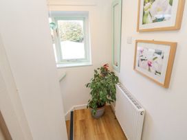 A hallway with a plant and framed pictures at Five Elements Barn in Truro