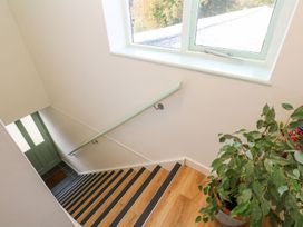 A stairway with a window and a plant at Five Elements Barn, Truro